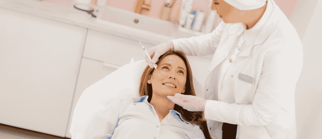Provider examining a patient's face before a Botox or dermal filler treatment