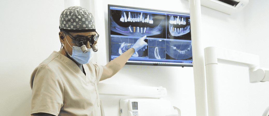 Oral surgeon reviewing 3D dental scans on a monitor