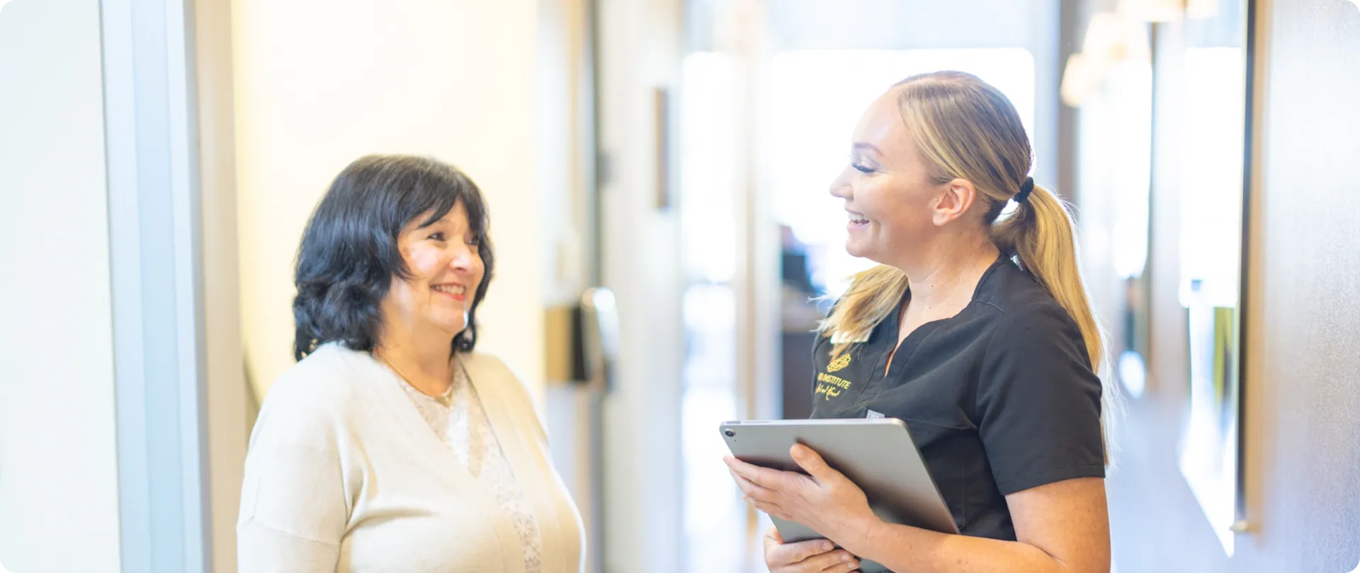 Inland Institute team member with a tablet greeting a patient