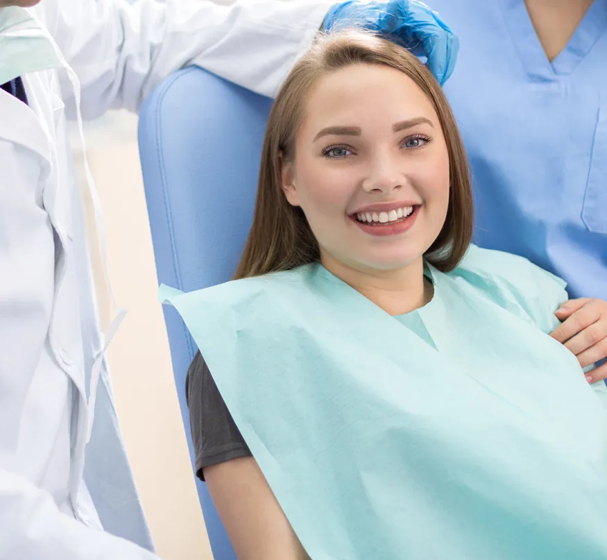 A smiling young woman in dental chair